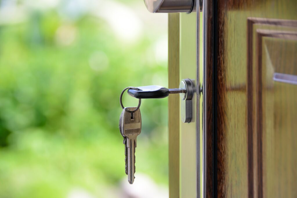 A set of keys in the lock of an open front door.
