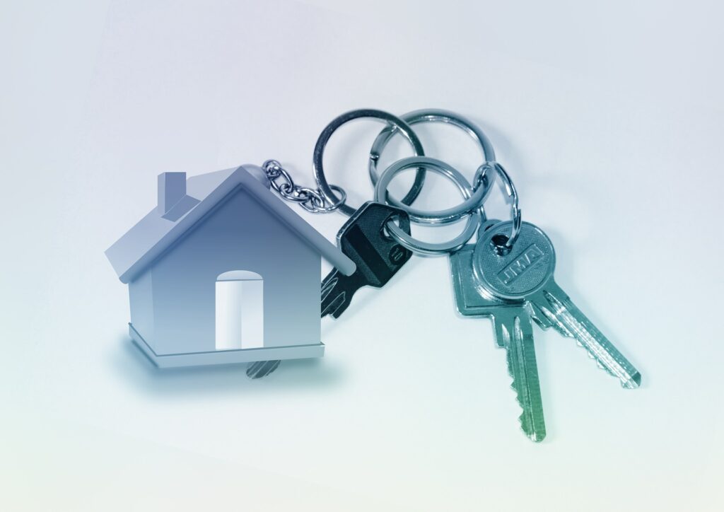 A set of house keys with a metal house keyring attached.