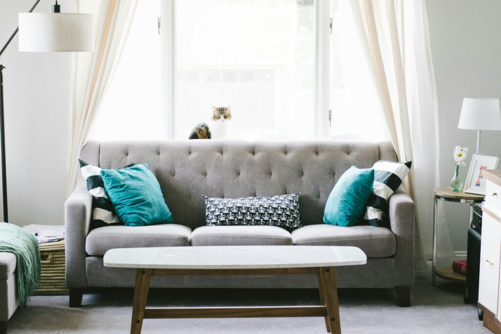 A grey sofa in a living room with blue, black and white cushions