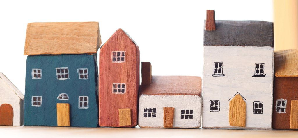 A row of model houses including blue, red and white houses of varying sizes