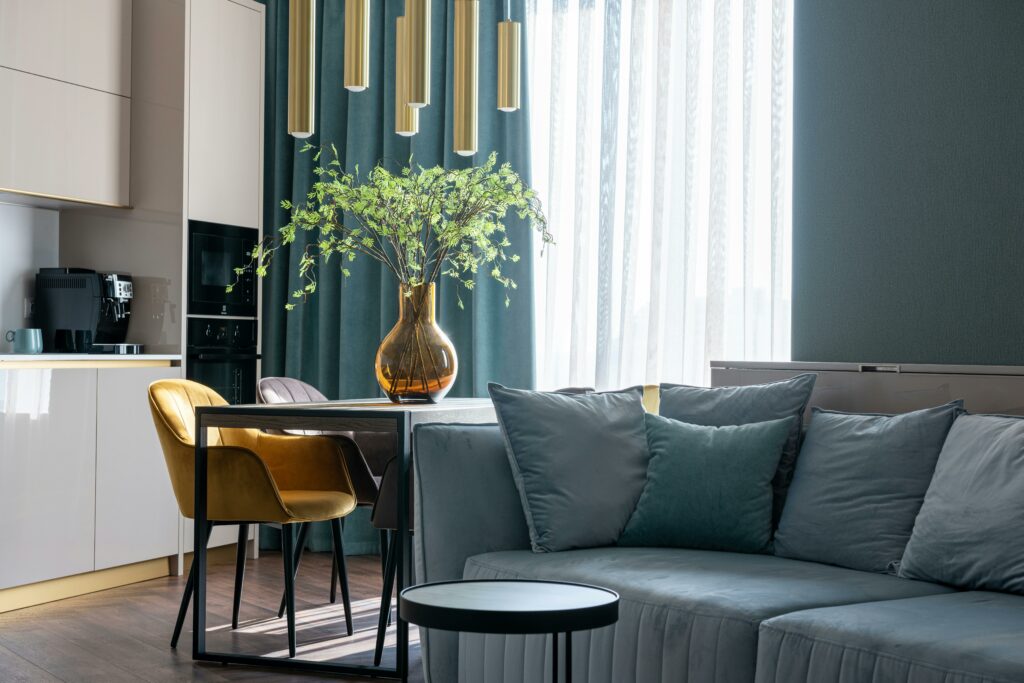 A modern living room with blue, grey and gold furniture and decor